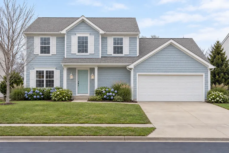 Coastal house exterior with pale blue shingle siding, white shutters, an aqua front door and blue hydrangeas, AI example design