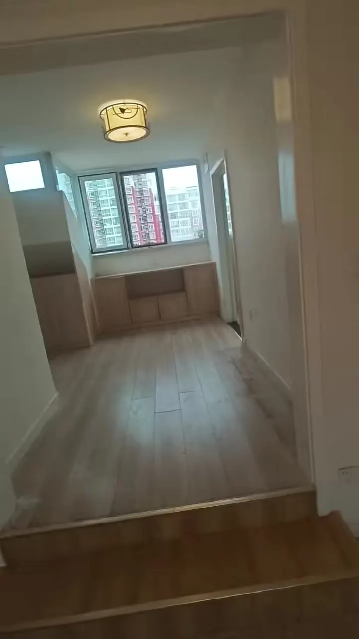 Real phone photo of the second flat's study with a bay window and low cabinet