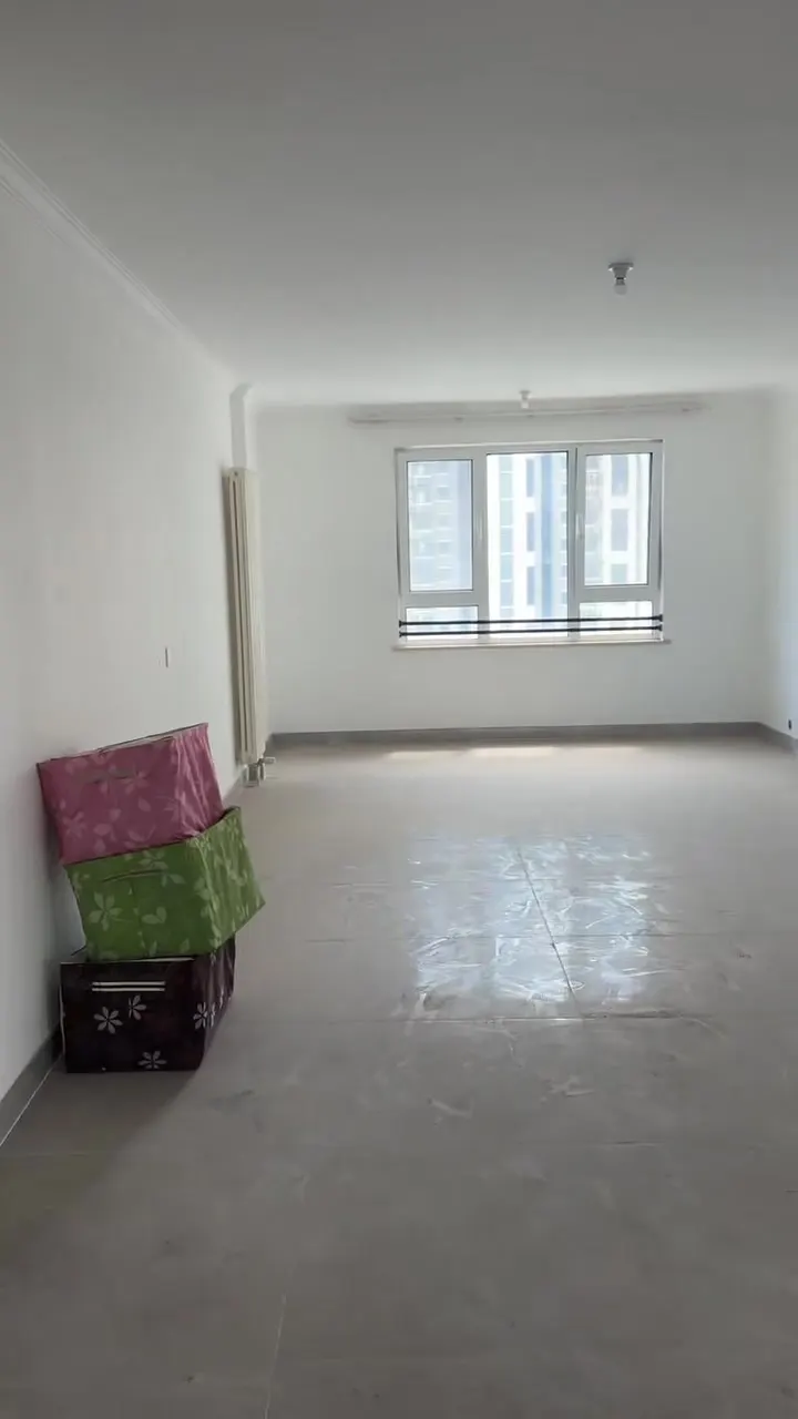 Real phone photo of the first flat's empty living room facing the window