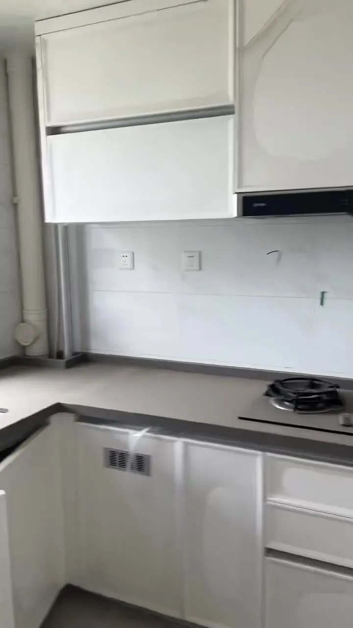 Real phone photo of the first flat's L-shaped kitchen